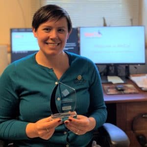 Kelli Ryan, WeCo Director of Operations, holding the company' Leading Disability Employer award trophy.