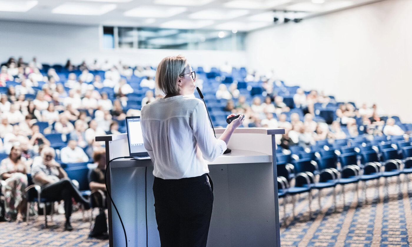 Female speaker giving a talk in front of an audience
